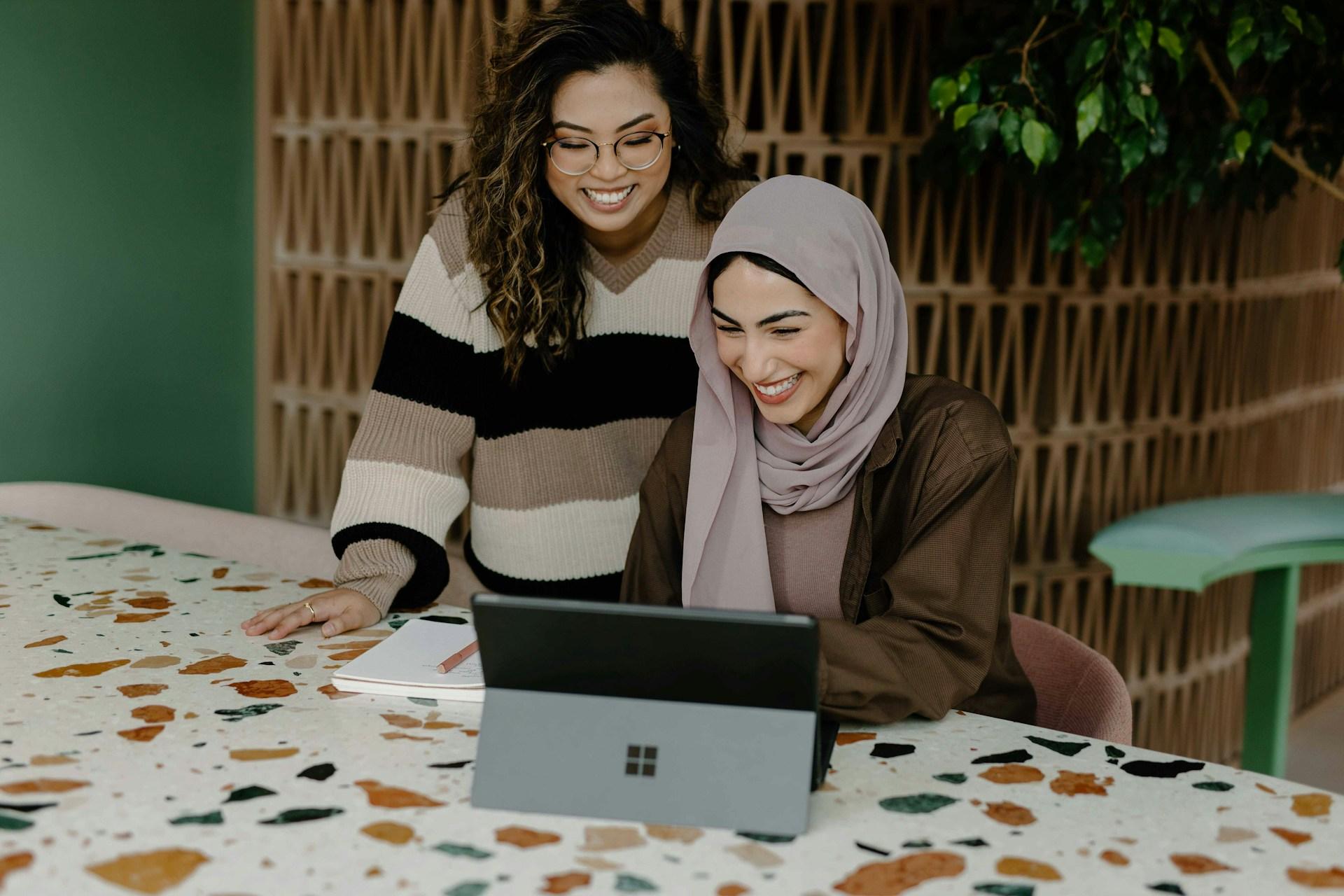 Two colleagues reviewing work together on a tablet